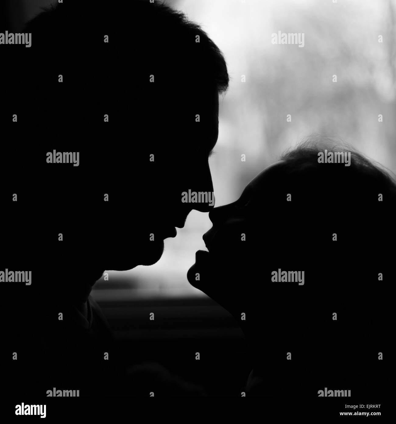 Una silhouette di un padre e di una figlia il naso a naso (eschimese baci); nero e bianco; colortone formato quadrato Foto Stock