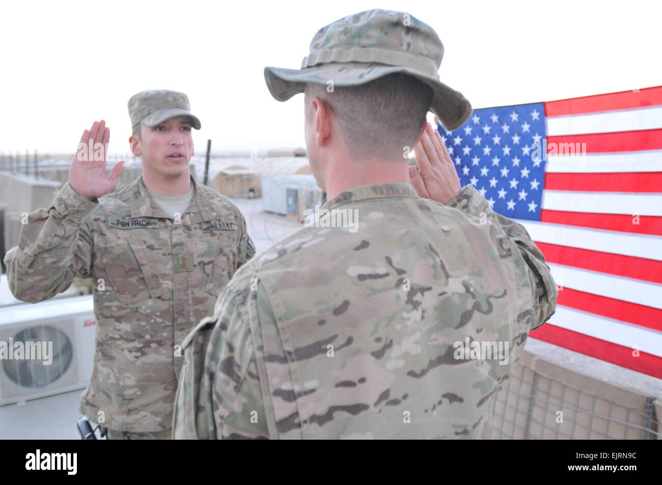 Secondo Lt. Adam Pontrich, un comandante di plotone per ottavo battaglione ingegnere, reenlists suo fratello Sgt. 1. Classe Alan Thomas, intelligenza sottufficiale, per la sede centrale e sede società, 3° della brigata di fanteria combattere la squadra, 1a divisione di fanteria in marcia avanti la base operativa di Apache, Afghanistan, Ottobre 17, 2013. Sgt. Toby Cook Foto Stock