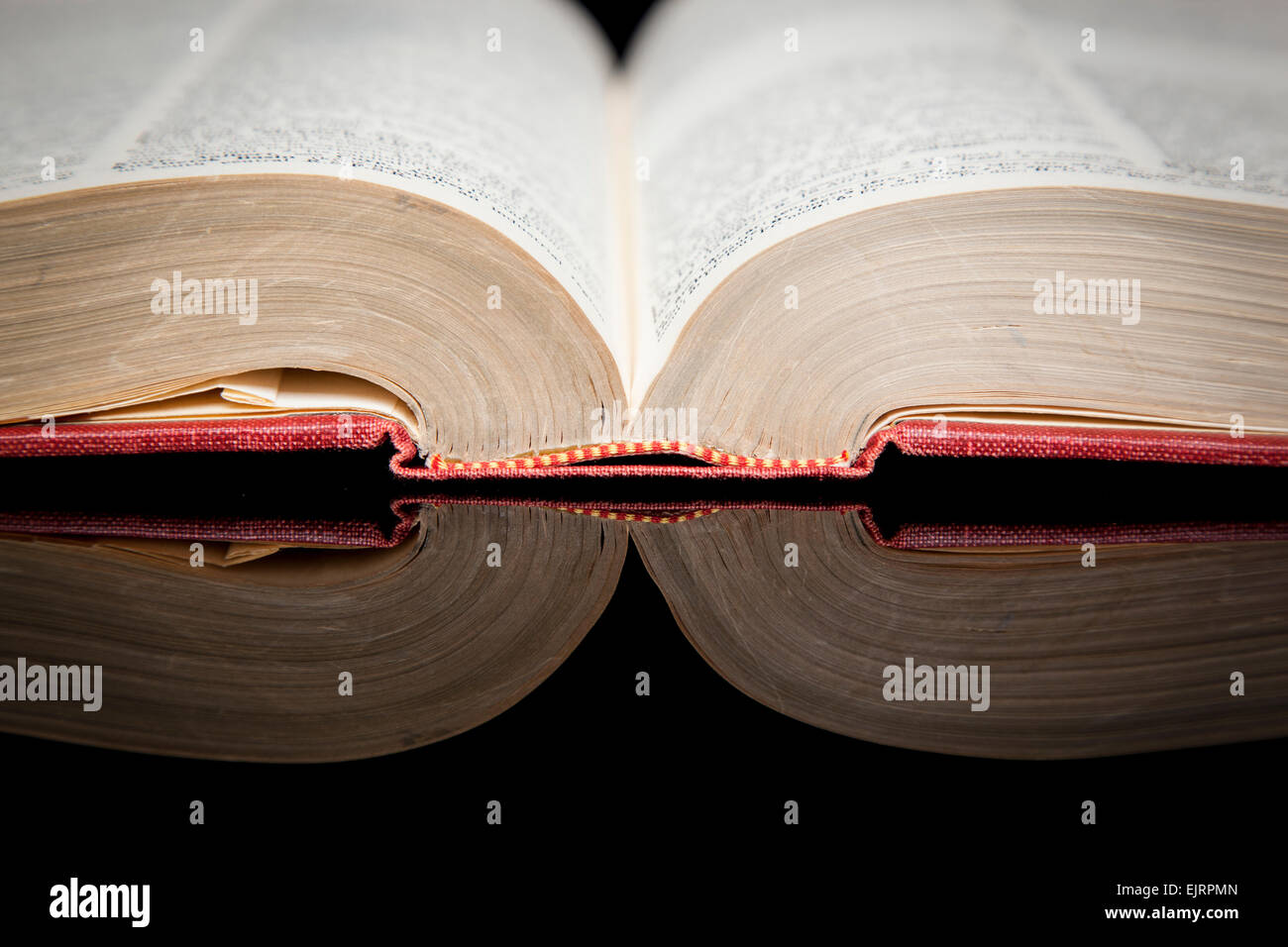 Un vecchio libro viene riflessa su un lucido la superficie nera Foto Stock