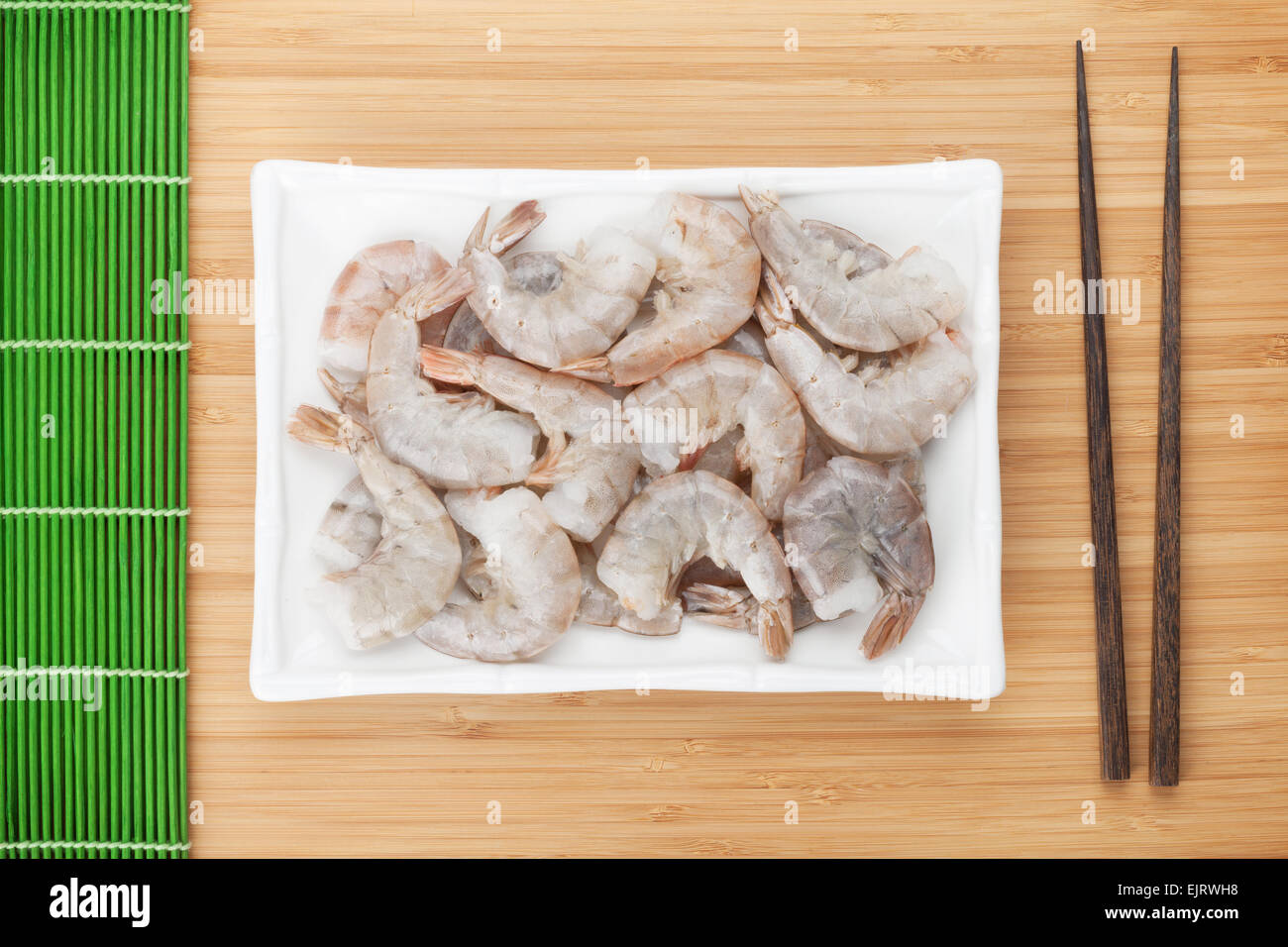 Materie non cotti i gamberetti piastra. Sulla tavola di bambù Foto Stock