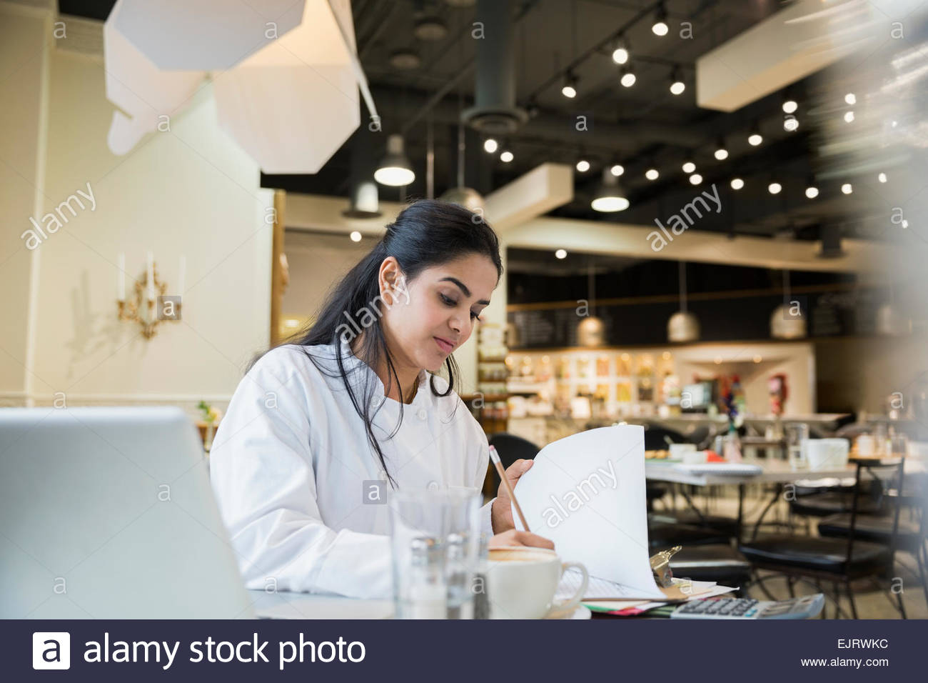 Lo Chef lavora su documenti cartacei in cafe Foto Stock