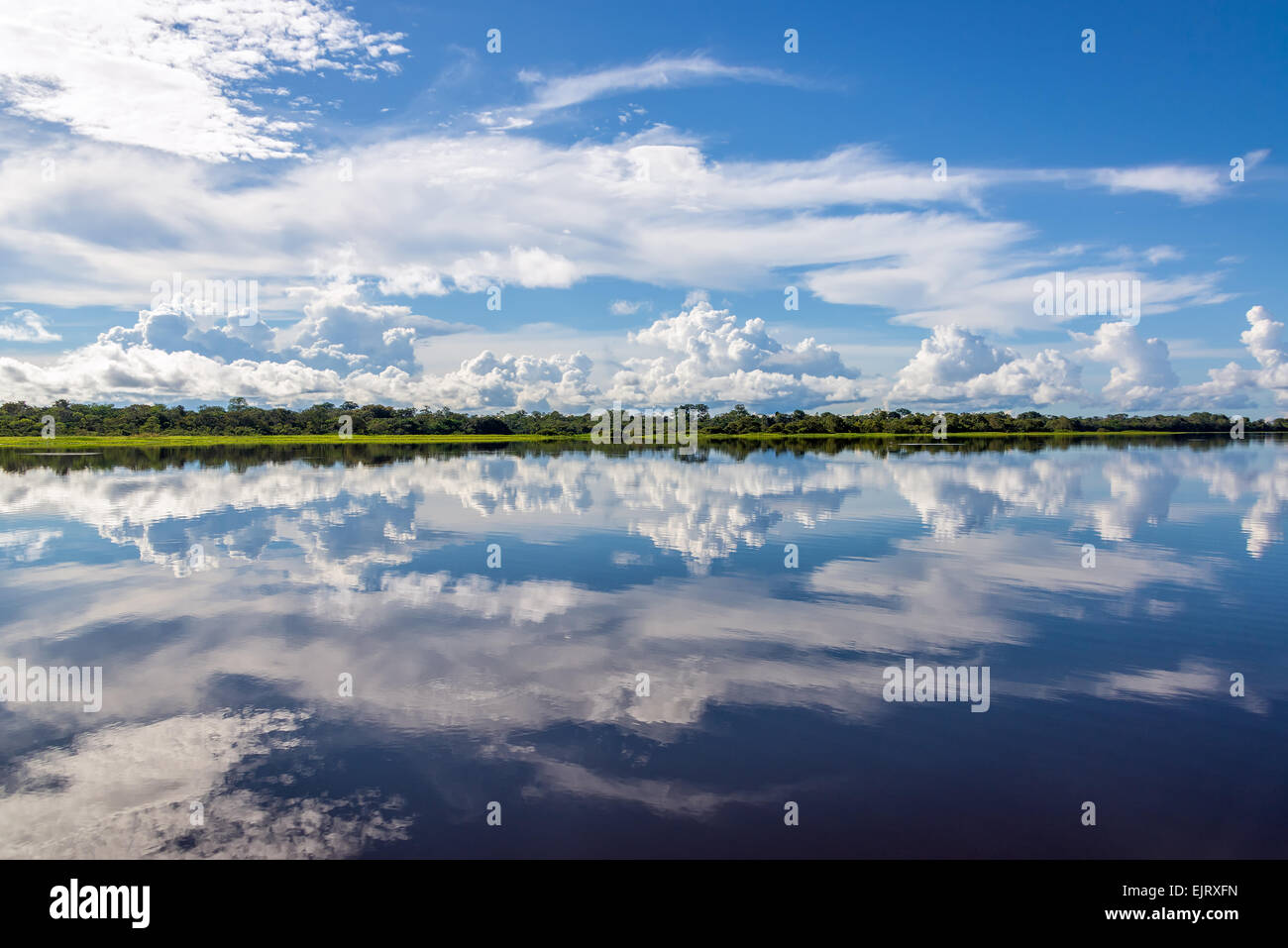 Sky riflessa nell'acqua su un lago nella foresta amazzonica in Perù Foto Stock