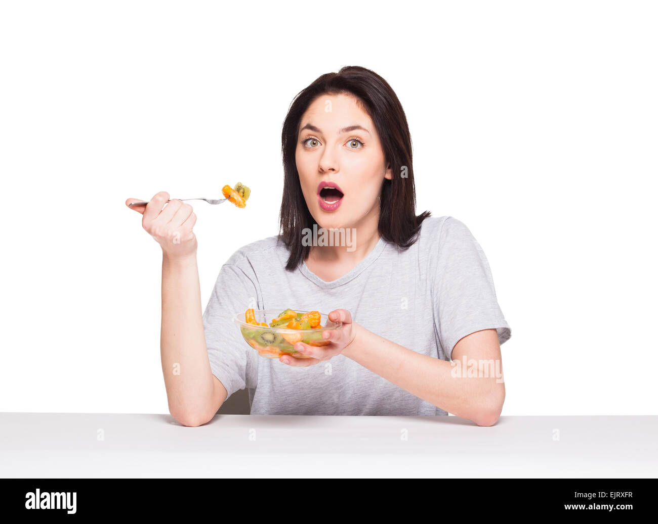 Donna naturale di mangiare cibo sano con arancia e kiwi su sfondo bianco Foto Stock