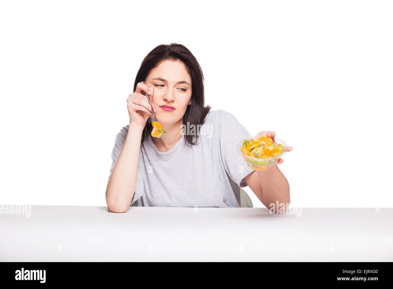 Giovane donna naturale cercando annoiato con il suo pasto sano, isolato su bianco Foto Stock