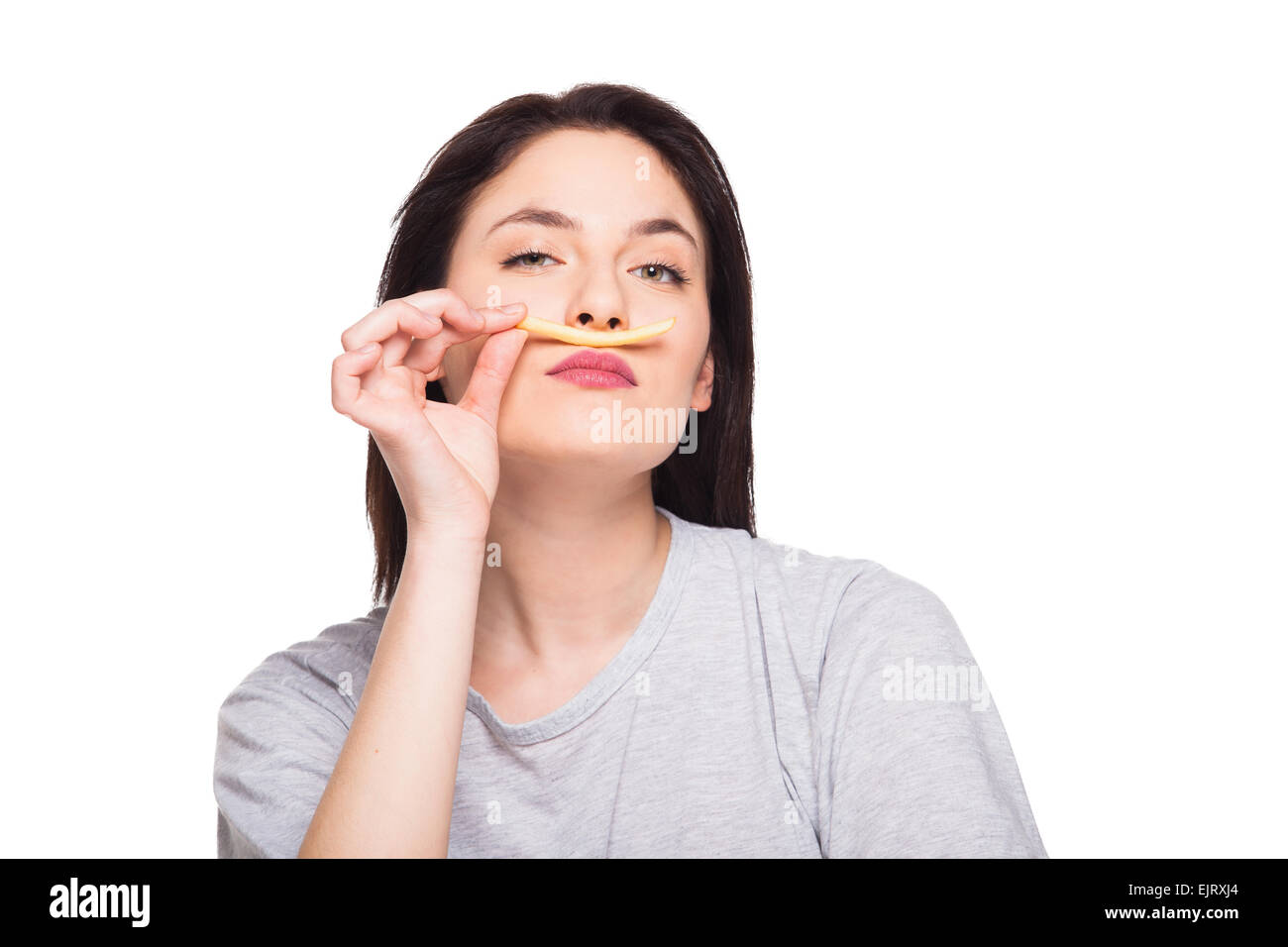 Naturale donna espressiva giocando con patatine fritte, avendo di fronte junk e cibo sano, isolato su bianco Foto Stock