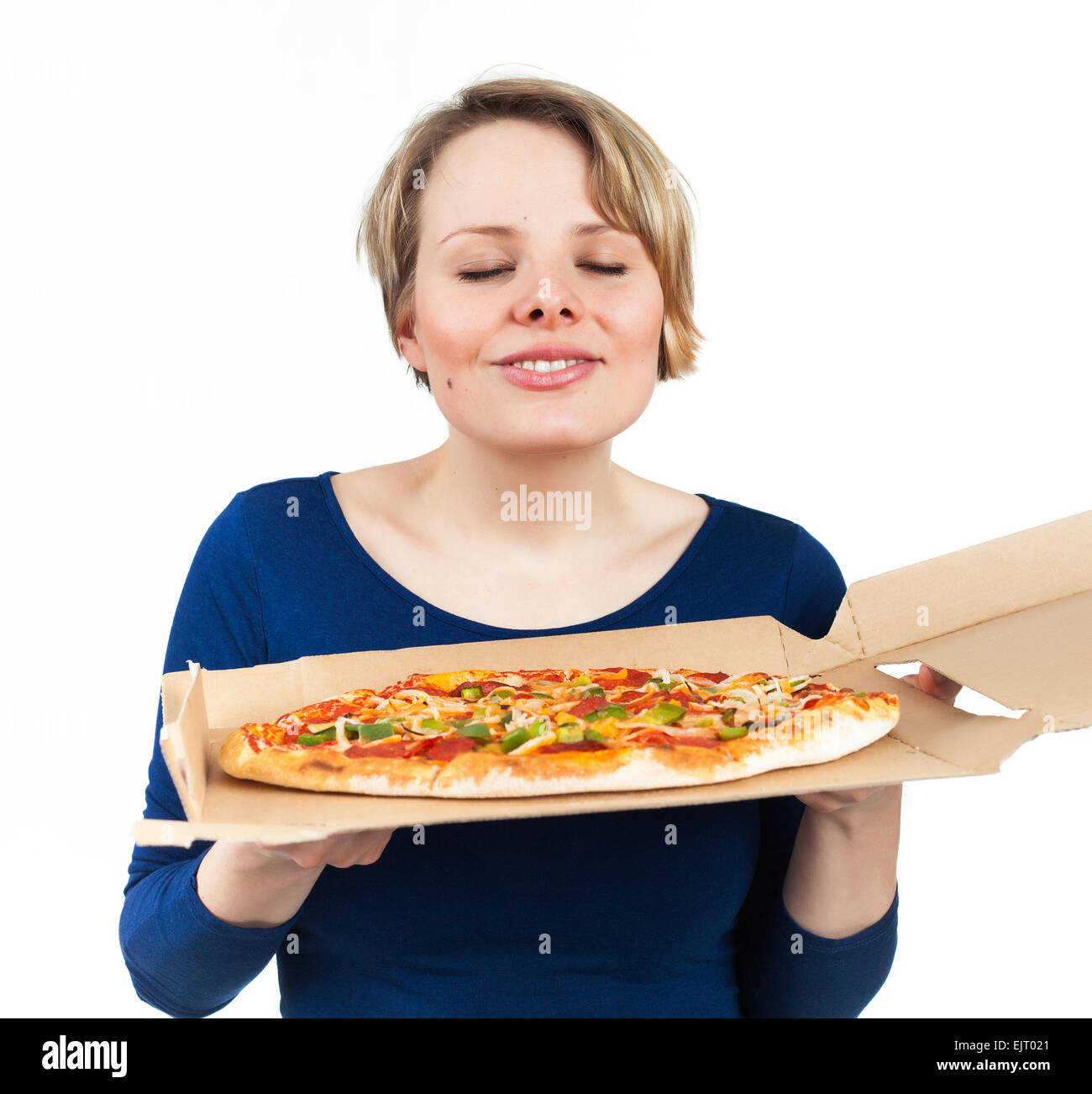 Giovane donna annusare una pizza dal fast food e guardando molto attratto, isolato su bianco Foto Stock