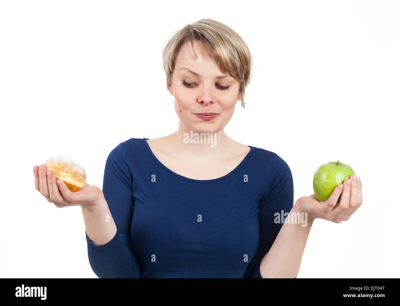 Giovane donna tra ciambella e apple, isolato su bianco Foto Stock