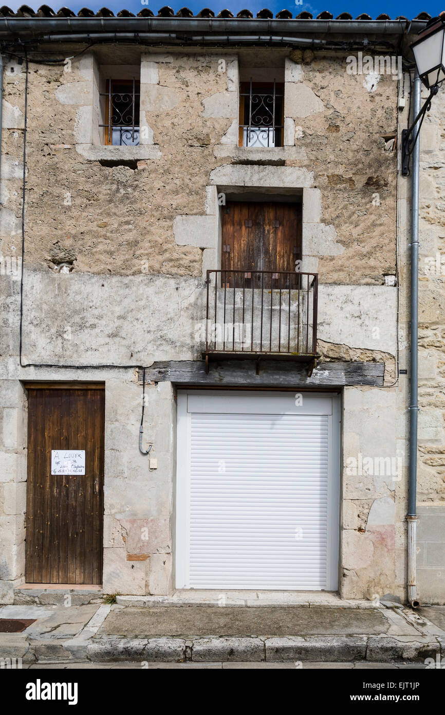 Facciata di una casa francese di pietra, parzialmente resi e un 'A Louer' (affitto) segno esposto. Foto Stock