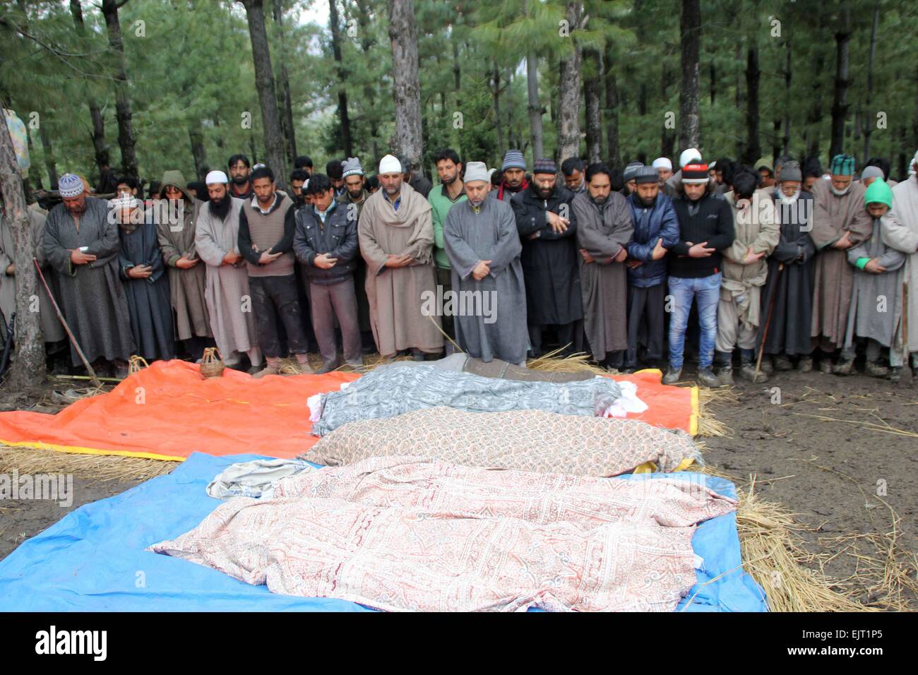 Srinagar Kashmir. Il 31 marzo, 2015. Gli abitanti di un villaggio di offrire preghiere funebri in Laden in Chadoora regione indiana del Kashmir amministrato il 31 marzo 2015. Sedici morti tra cui una settimana di età bambino dopo una frana provocata dalle forti piogge sepolto diverse case. Credito: NISARGMEDIA/Alamy Live News Foto Stock