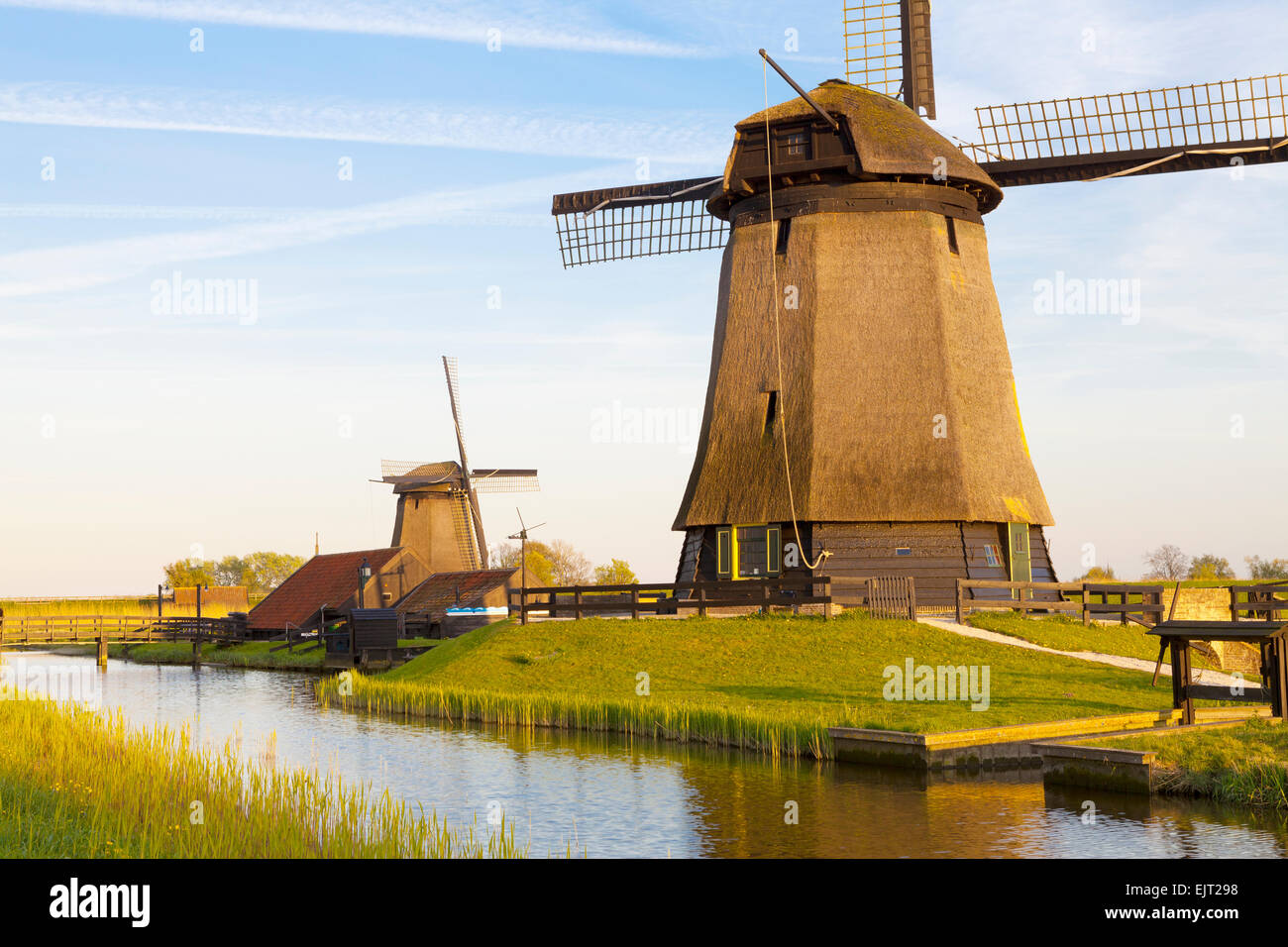 Mulini a vento tradizionali accanto a un canale, Schermerhorn, North Holland, Paesi Bassi Foto Stock