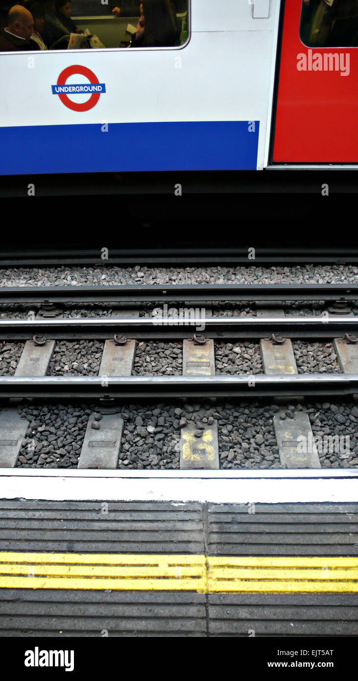 Un tubo di linea e di piattaforma con un treno in background Foto Stock