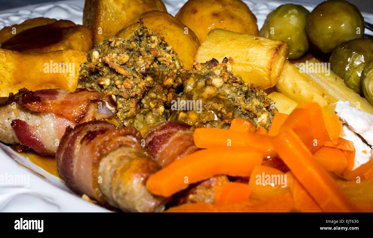 Cena di Natale costituito da suini in coperte, Turchia, patate arrosto, arrosto pastinaca, carote, i cavoletti di Bruxelles e il ripieno. Foto Stock