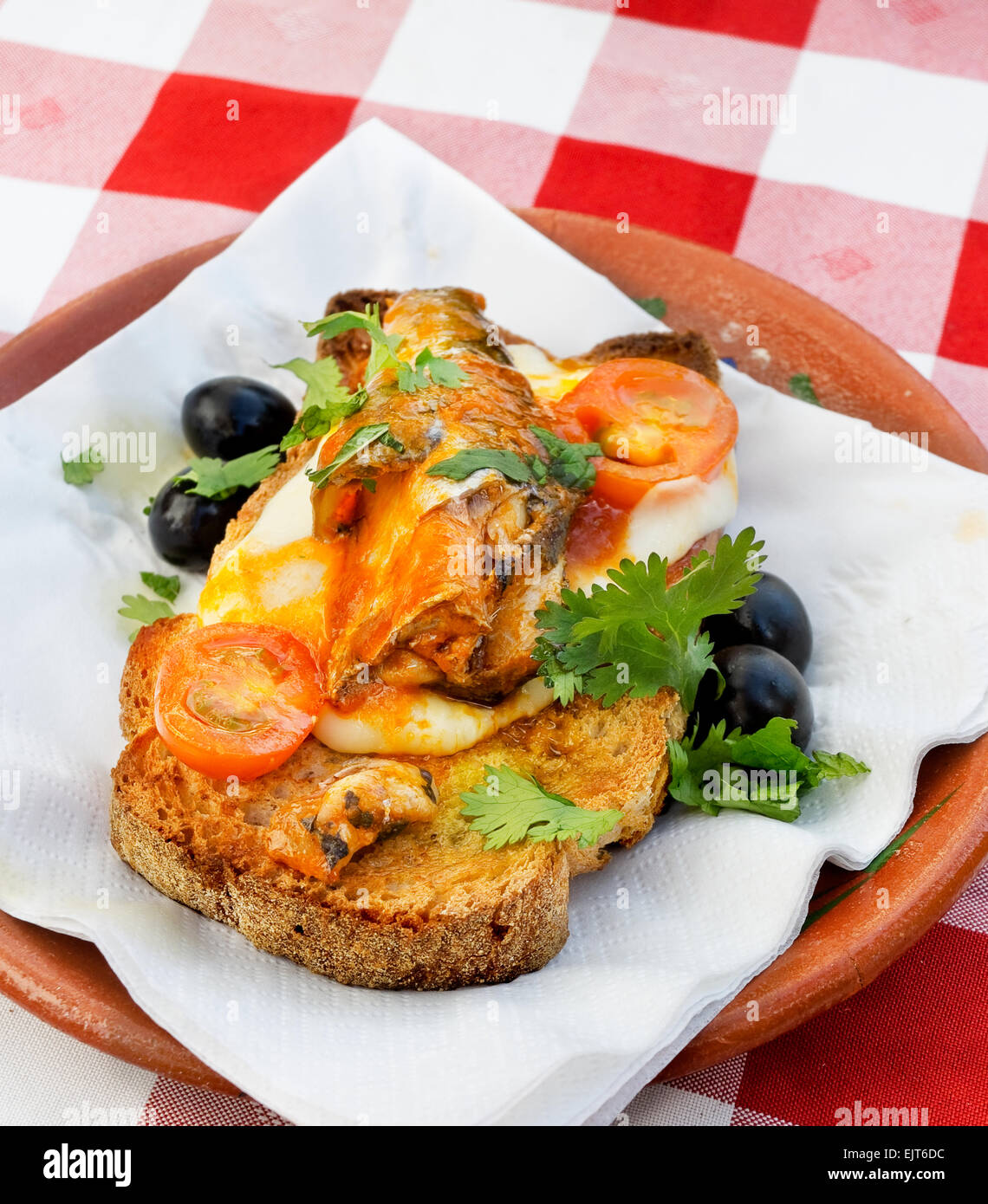 Sardine e bruschetta di pomodoro in un rustico di presentazione. Foto Stock