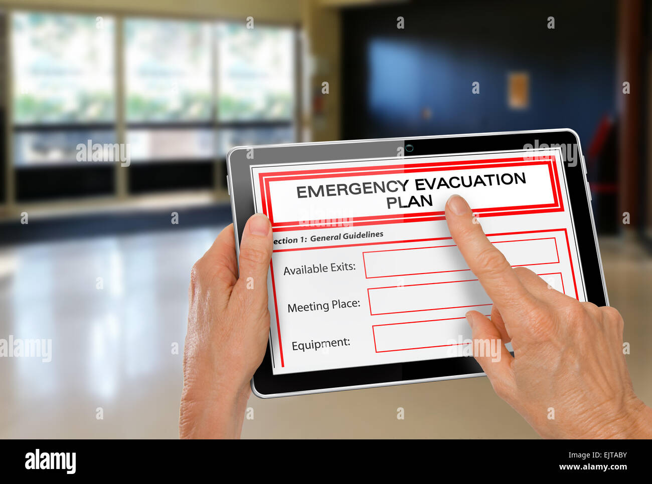 Le mani con il computer Tablet di completare l'evacuazione di emergenza piano App da porte di uscita Foto Stock