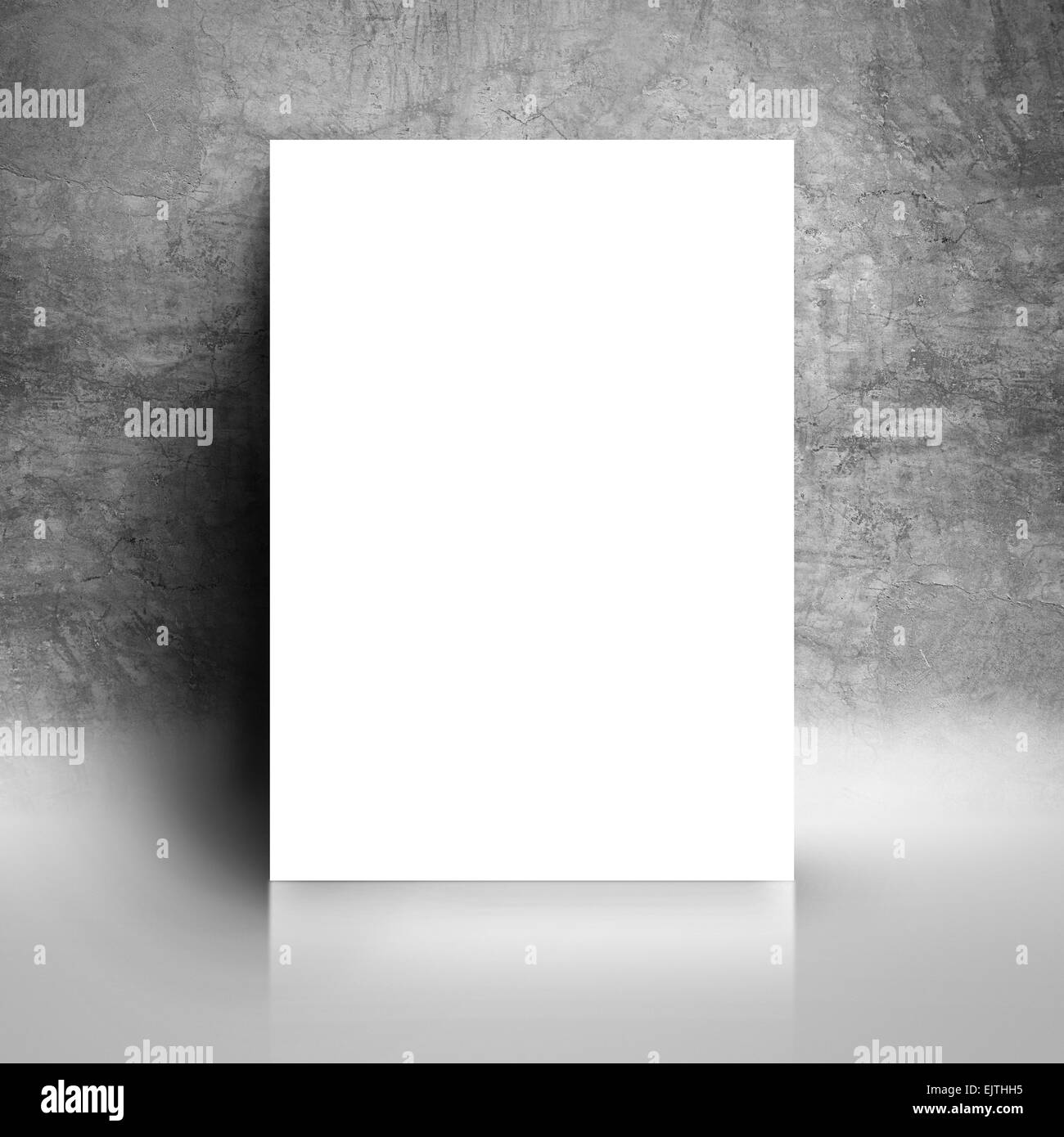 Vuoto bianco Poster della carta appoggiata su grunge Studio grigio della parete della camera come copia di spazi per la progettazione e il modello Mock up per aggiungere il tuo T Foto Stock