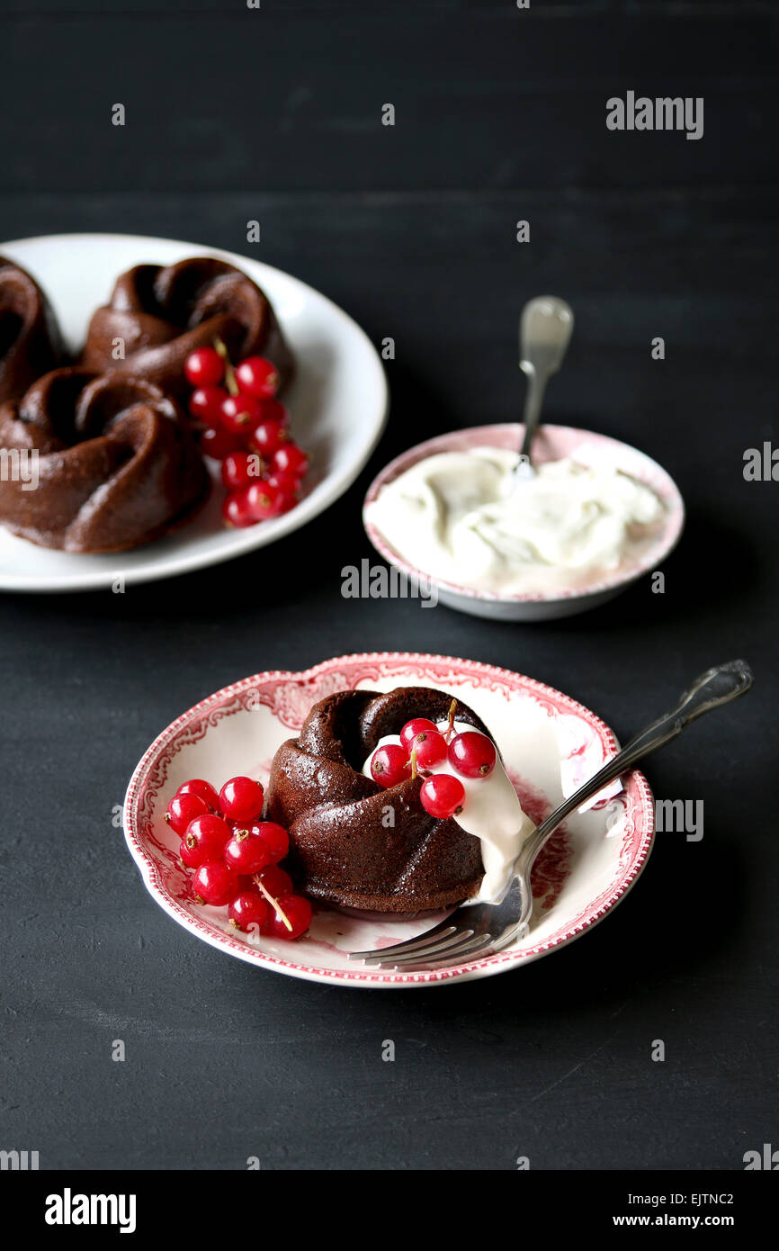 Bundt cioccolato torta con ribes rosso e panna montata Foto Stock