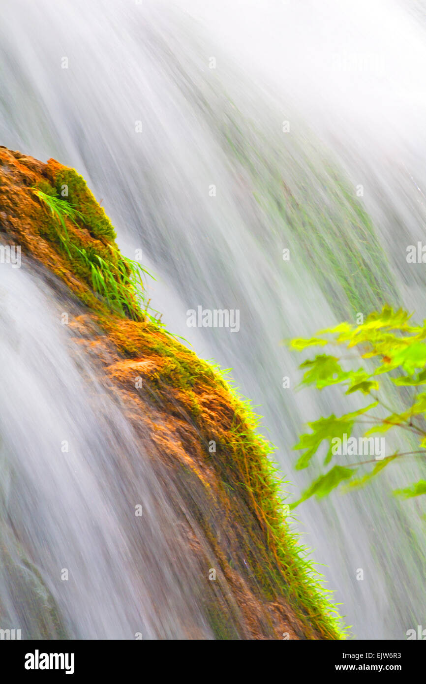 Effetto pittorico di cascata con acqua che cade su rocce e. verde astratto Foto Stock