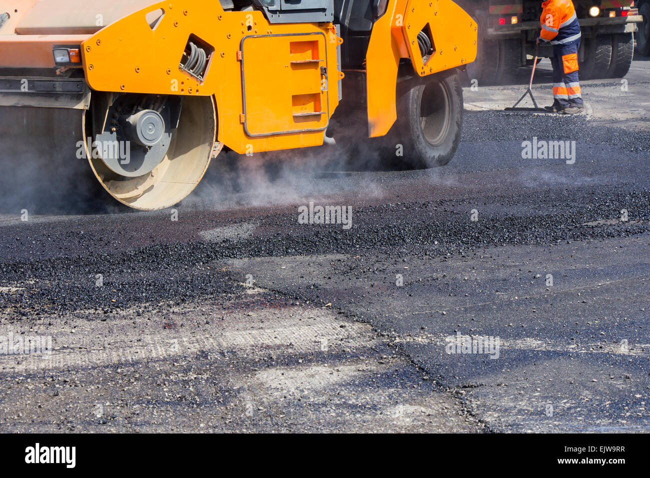Rullo e lavoratori su asfaltatura e la riparazione delle strade della città Foto Stock