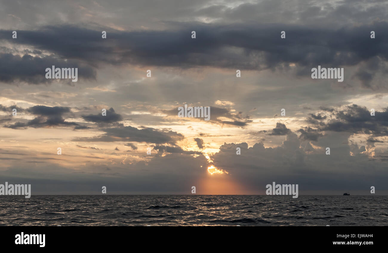 Cielo di tramonto con drammatica nuvole temporalesche oltre oceano. Foto Stock