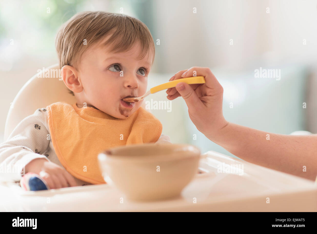 Alimentazione madre piccolo ragazzo (2-3) con paletta Foto Stock