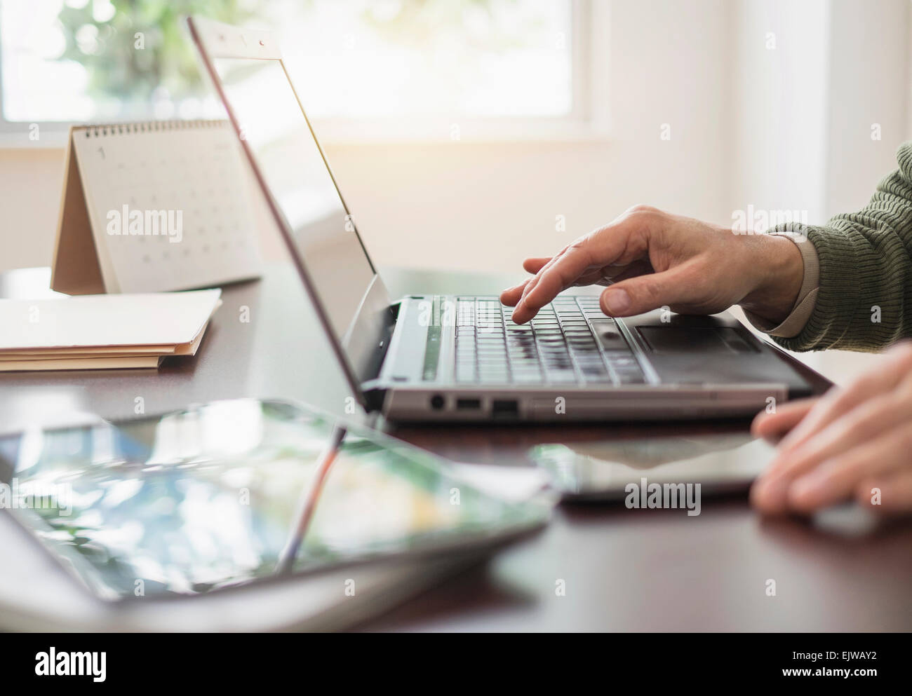 In prossimità delle mani dell'uomo utilizzando laptop alla scrivania Foto Stock