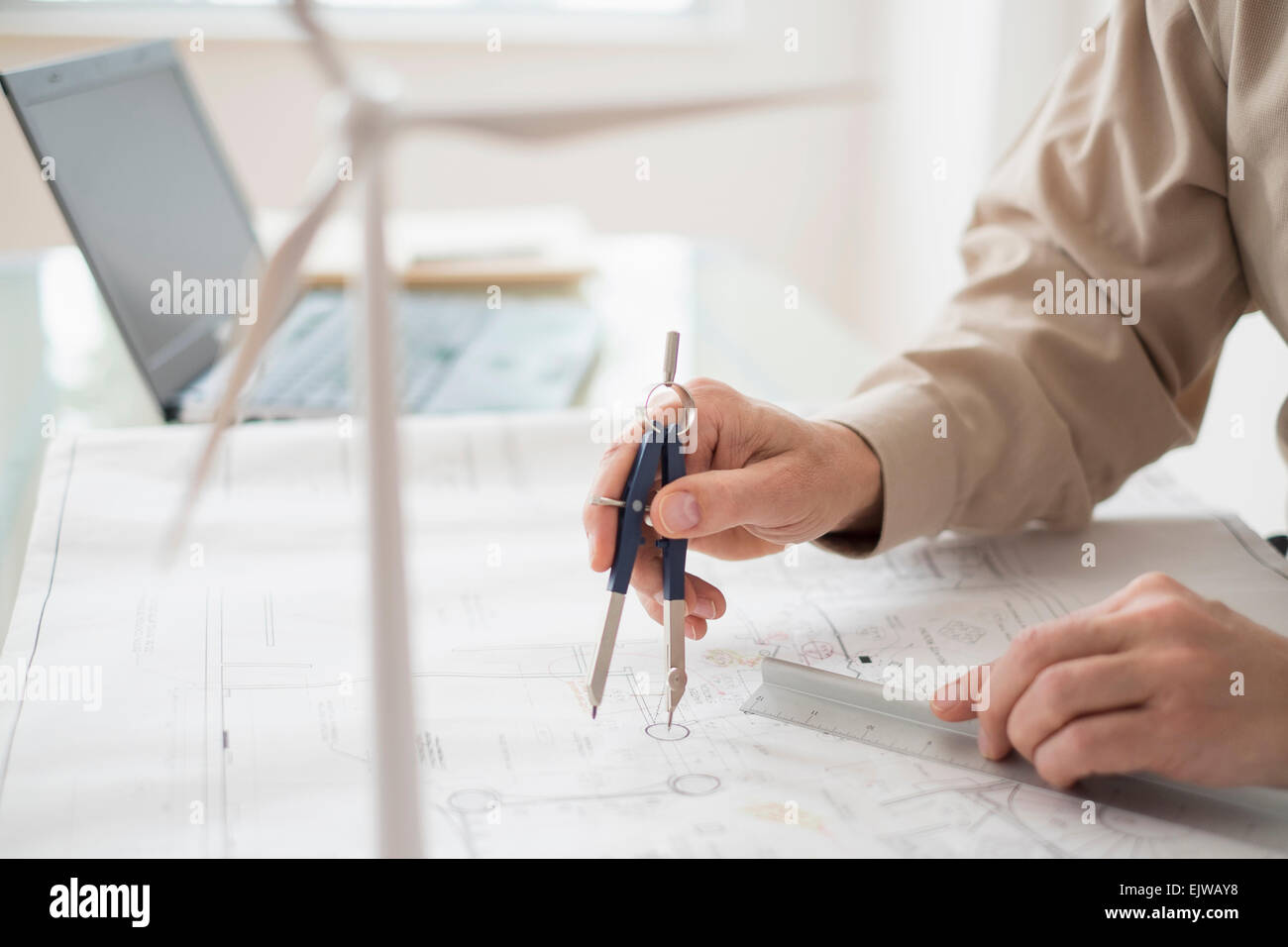 In prossimità delle mani dell'uomo con la bussola mentre i piani di disegno Foto Stock