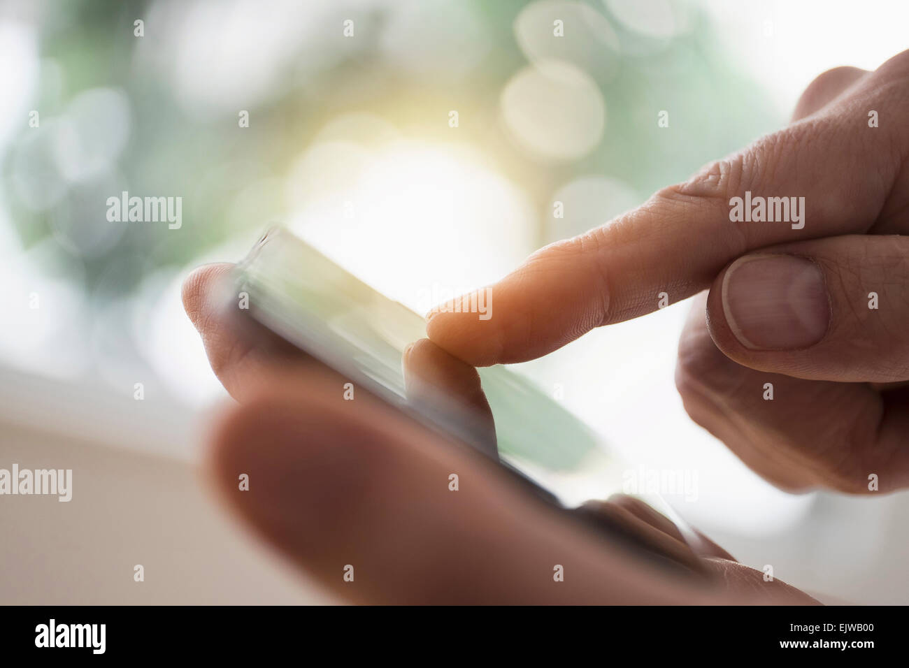 Stretta di mano d'uomo utilizza lo smartphone Foto Stock