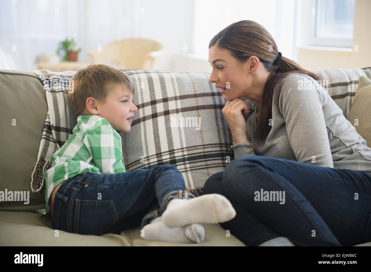Madre e figlio (6-7) seduto sul divano Foto Stock
