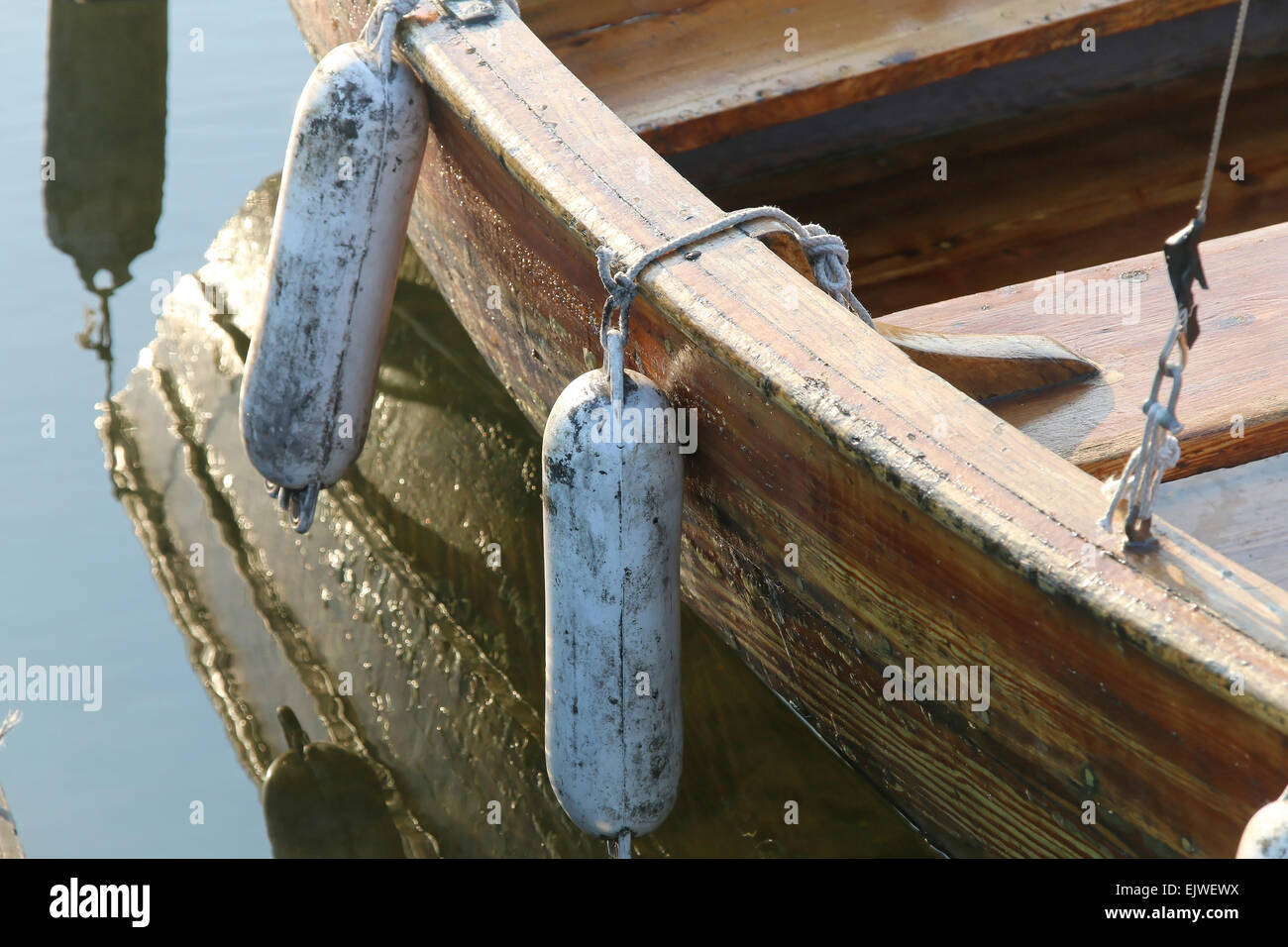 Le riflessioni di riga barca in acqua calma Foto Stock
