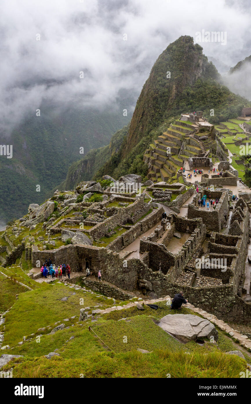 Il Perù, Machu Picchu. Guardando verso il basso sulla parte occidentale del settore urbano, Uña Picchu dietro il Intiwatana (aggancio di Post del Sole). Foto Stock