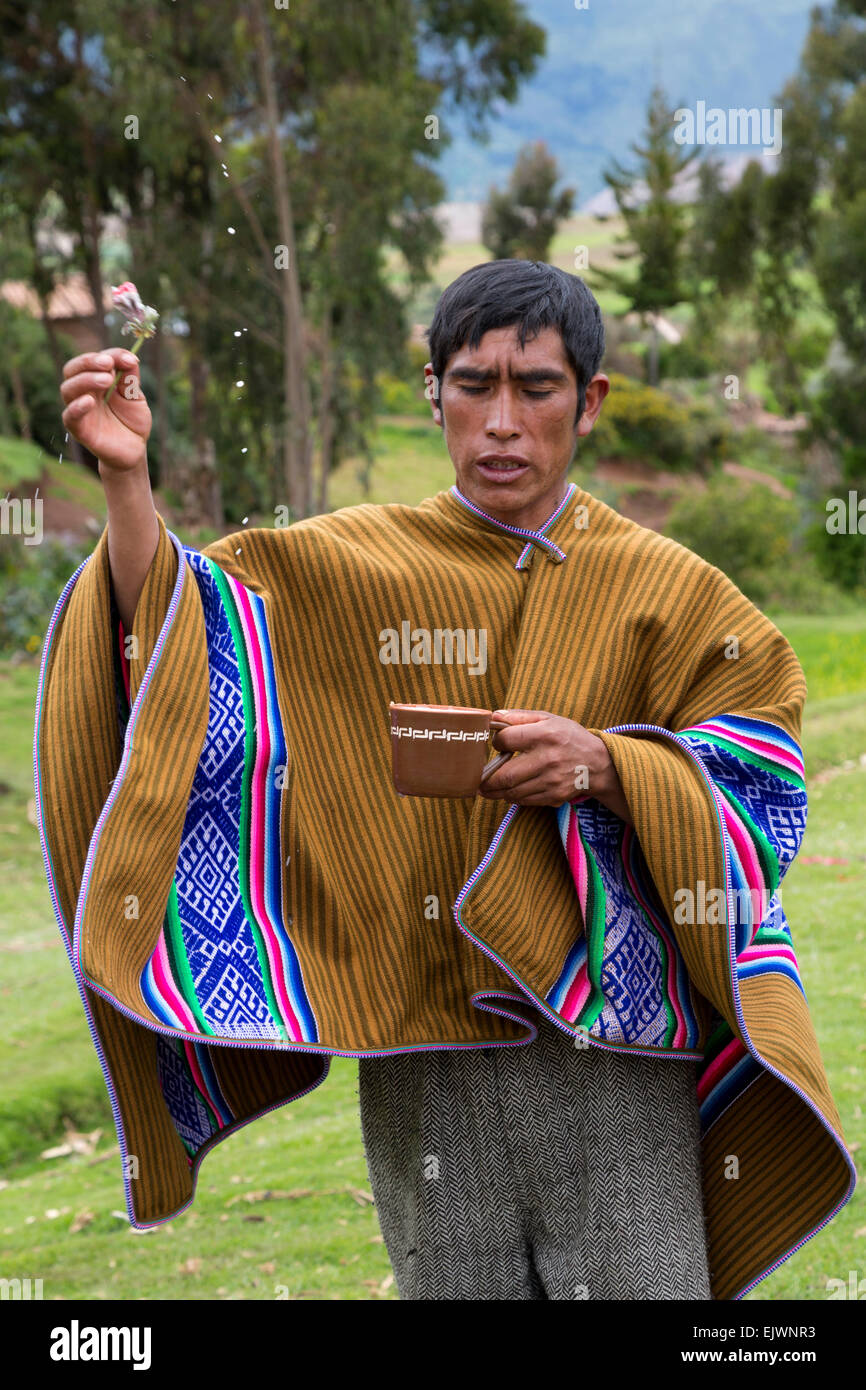Il Perù, Valle di Urubamba, Quechua Village. Sacerdote di eseguire una cerimonia di benvenuto per gli ospiti, spargendo Chicha per gli spiriti. Foto Stock
