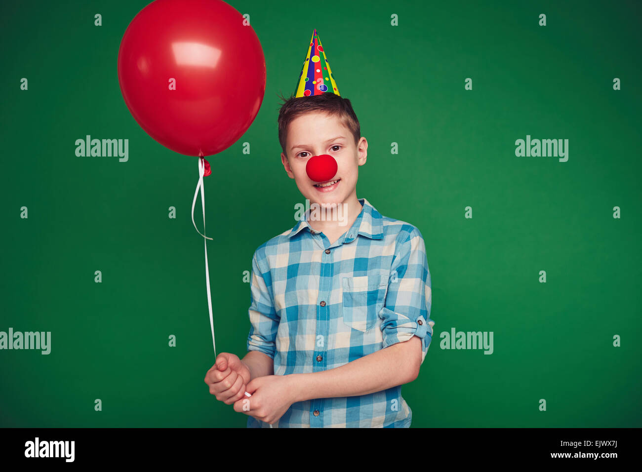 Ragazzo carino con palloncino a celebrazione di compleanno guardando la fotocamera Foto Stock