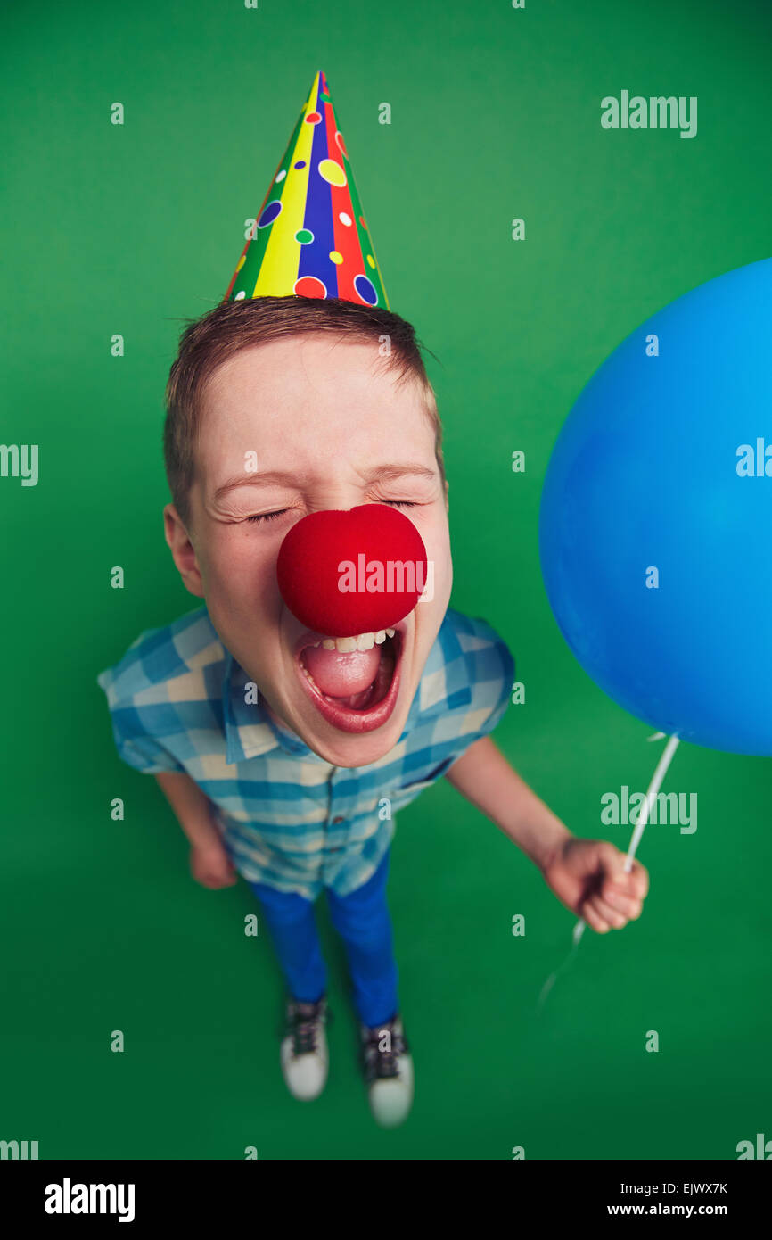 Pippo ragazzo con palloncino e clown naso gridando a Fool's Day celebrazione Foto Stock
