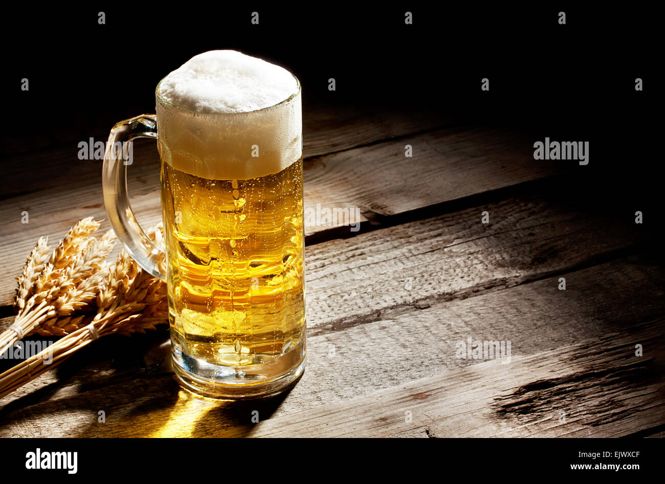 Bicchiere di birra chiara con spikelets sul tavolo di legno Foto Stock