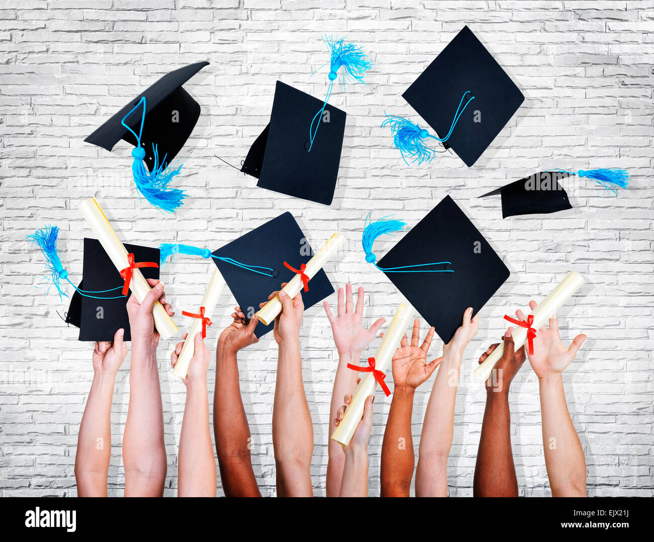 Gruppo di mani tenendo i diplomi e gettando la laurea cappelli nell'aria. Foto Stock