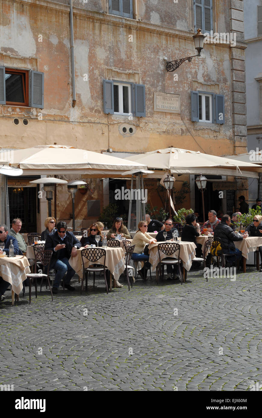 Persone mangiare fuori in Piazza Santa Maria in Trastevere, Roma. Foto Stock