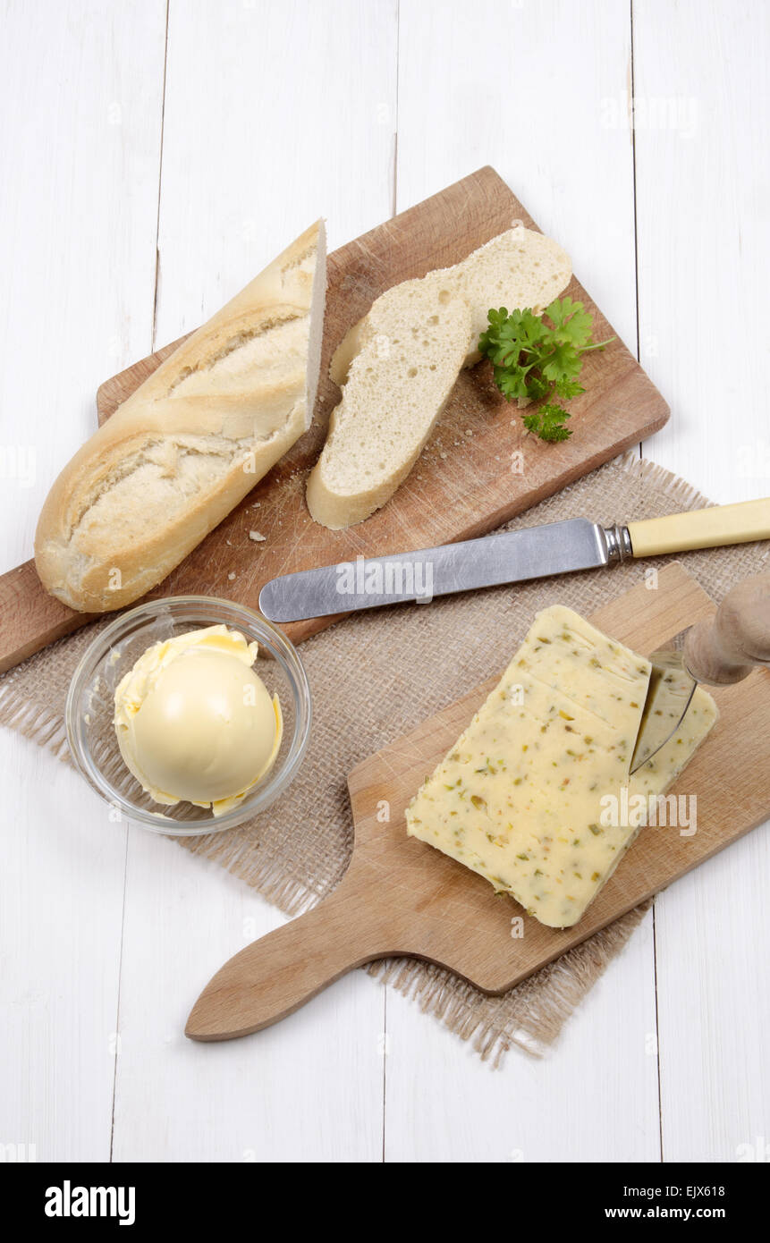 Formaggio con peperoncino jalapeno e baguette, margarina e prezzemolo con Coltello per formaggio sulla tavola di legno Foto Stock