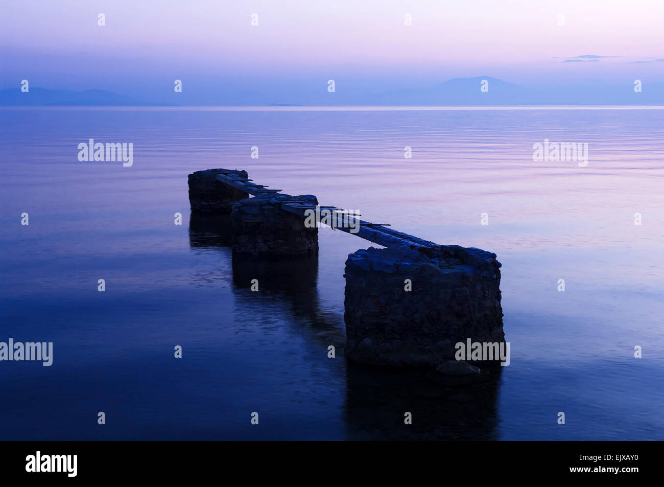 Il vecchio molo nel Golfo Pagasitic presso la costa della penisola di Pelion (Grecia) dopo il tramonto Foto Stock