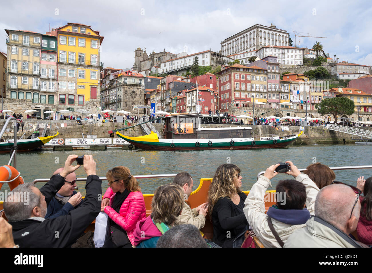 Gruppo di toursits scattare foto della città vecchia mentre vela lungo il fiume Douro, Porto, Portogallo Foto Stock