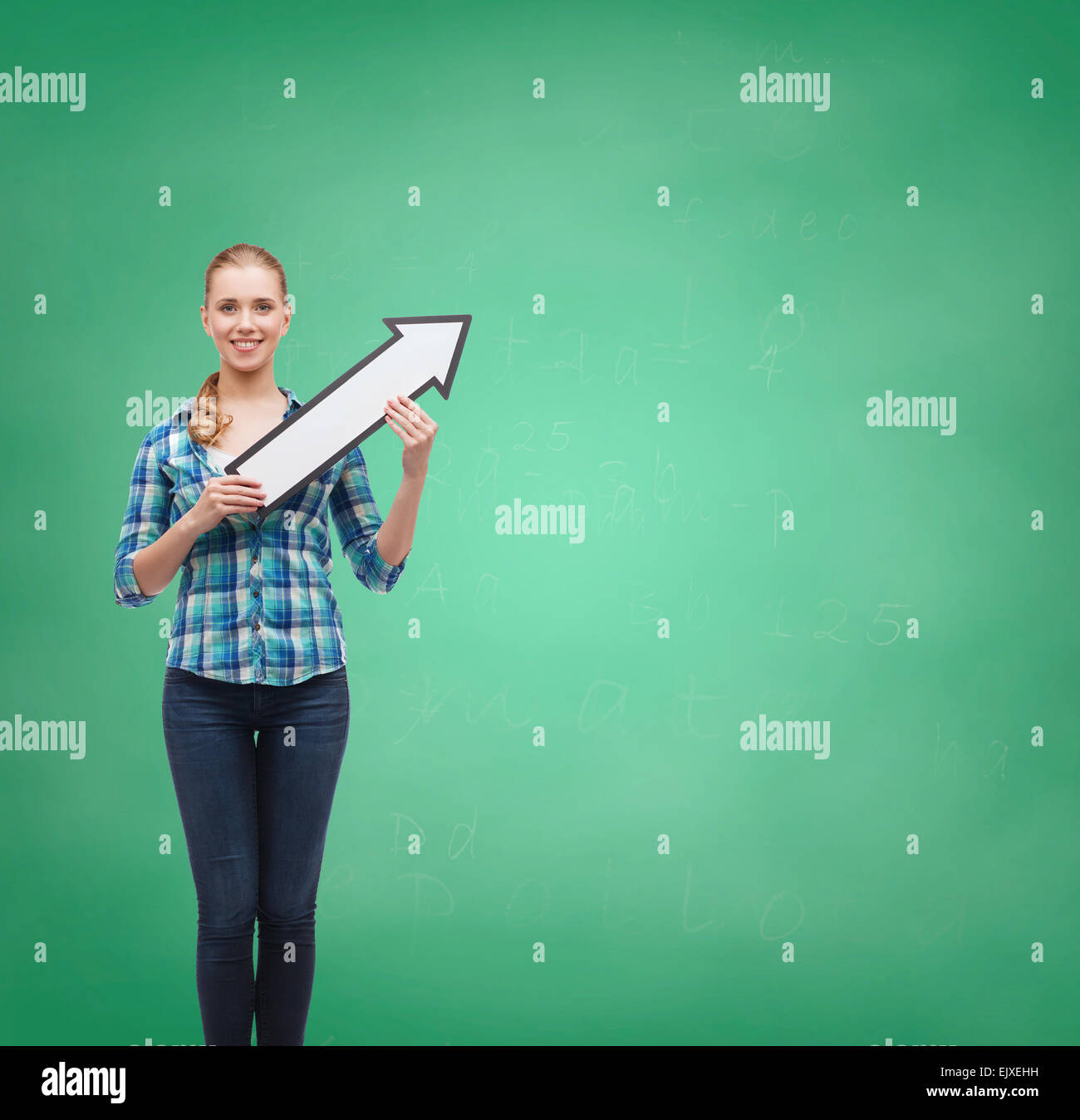 Sorridente giovane donna con la freccia poiting fino Foto Stock
