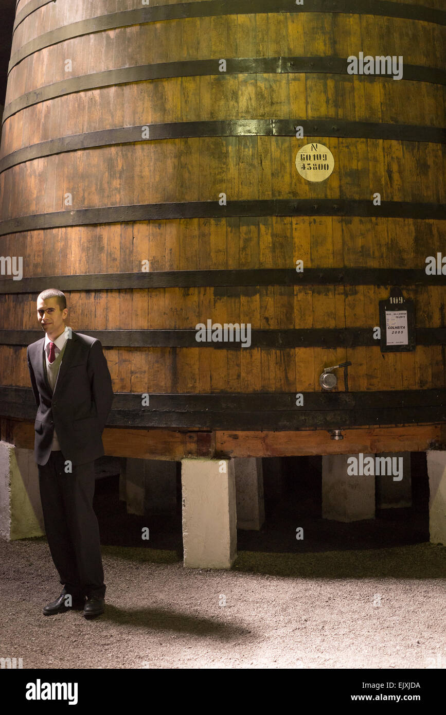 Tour guidato intorno il Croft cantine di Porto Portogallo. con guida in piedi accanto al legno grande contenitore di storage. Foto Stock