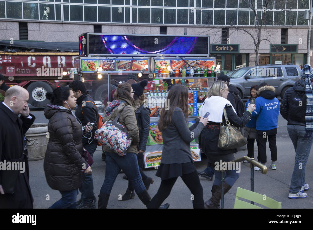 Le persone sono costantemente texting, parlando e il controllo dell'e-mail sui loro telefoni cellulari come essi a piedi nel centro di Manhattan. 42Nd Street. Foto Stock