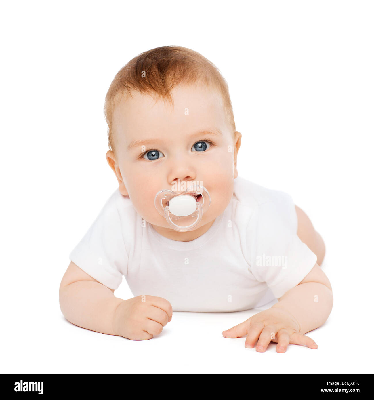 Sorridente Bambino giacente sul piano con ciuccio in bocca Foto Stock