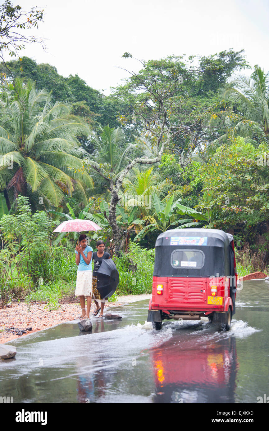 In rickshaw guidando attraverso il monsone di flood Foto Stock
