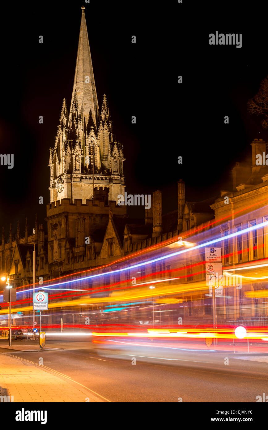 L'università chiesa di St Mary, Oxford, Regno Unito dalla High Street come traffico passando da foglie di sentieri di luce Foto Stock