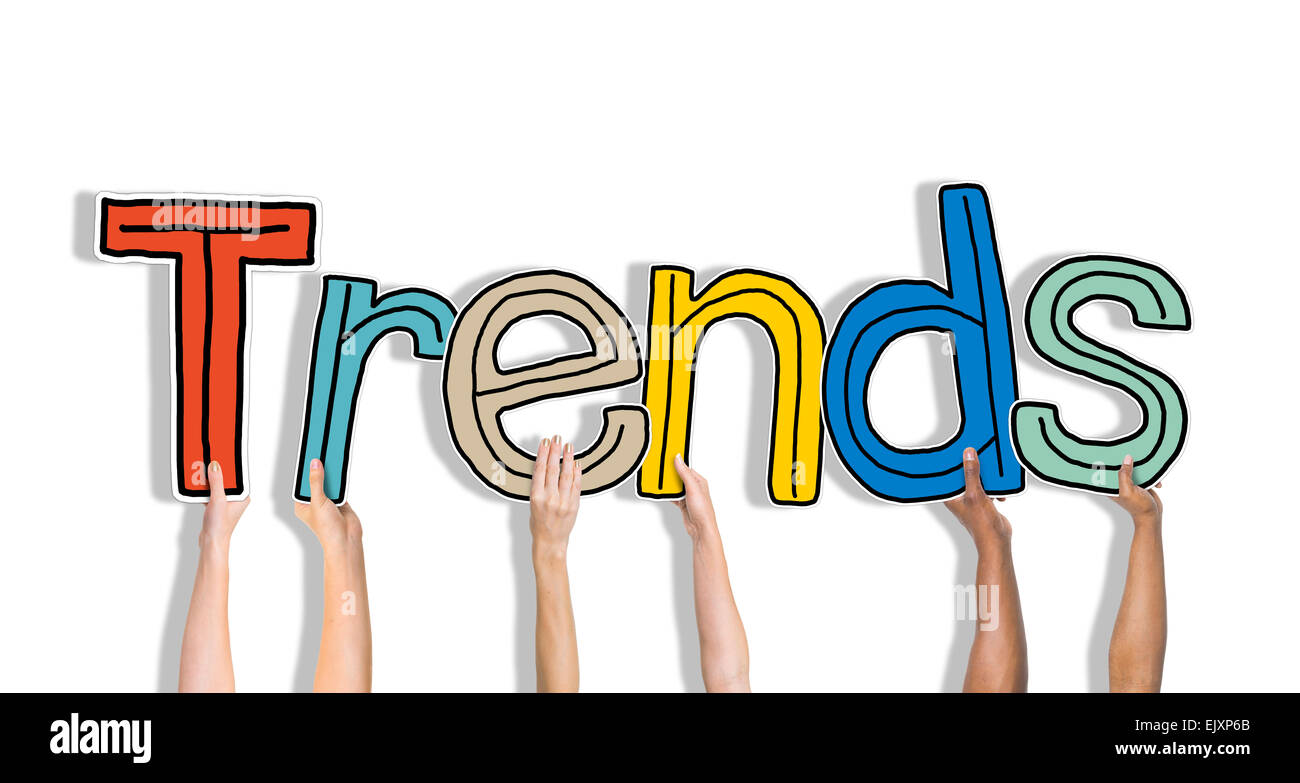 Diverse mani tenendo la parola tendenze Foto Stock