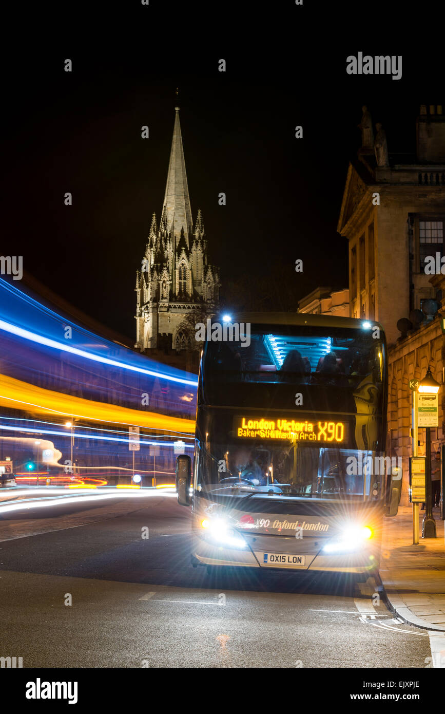 Autobus per la stazione di London Victoria su High Street, Oxford town center dietro il quale è la guglia della chiesa universitaria di St Mary Foto Stock