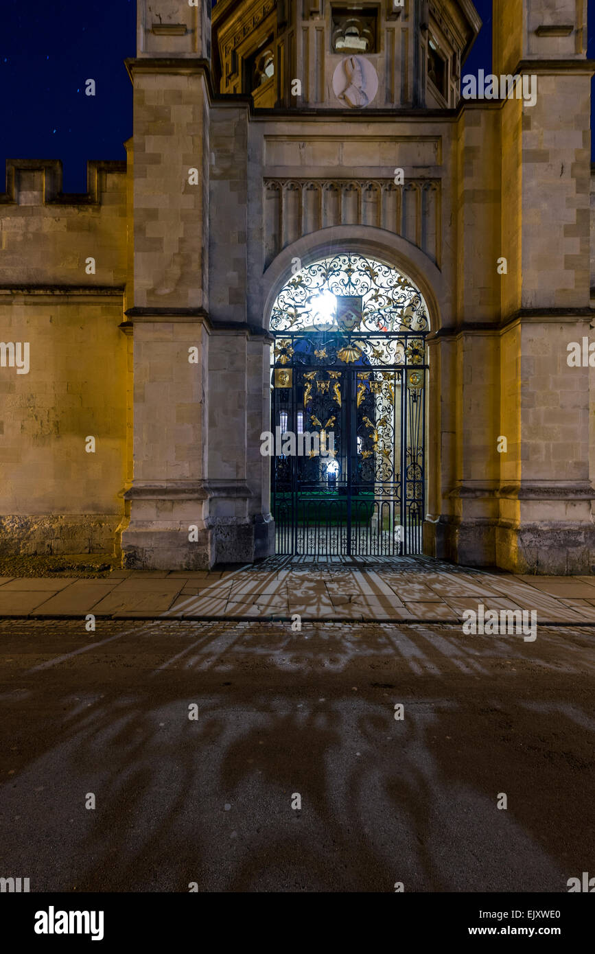 Il cancello per tutte le anime College di Oxford University da Radcliffe Square. Visto di notte, ferro battuto getta un'ombra. Foto Stock