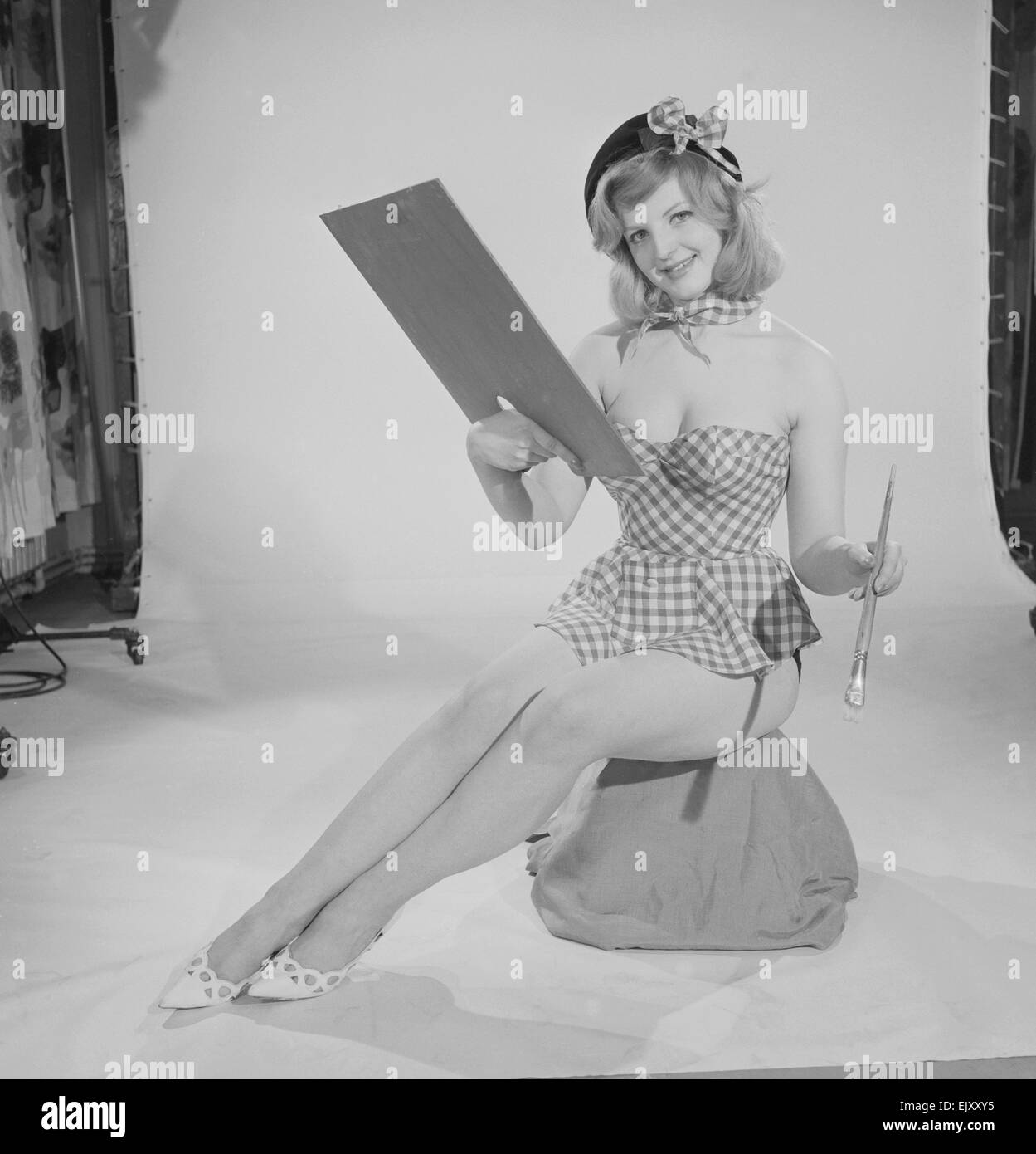 Sveglia funzione d'arte. Modello di gabbia di Peggy visto qui indossando un controllo corto abiti estivi tenendo una tavolozza e pennello circa nel 1960 Foto Stock