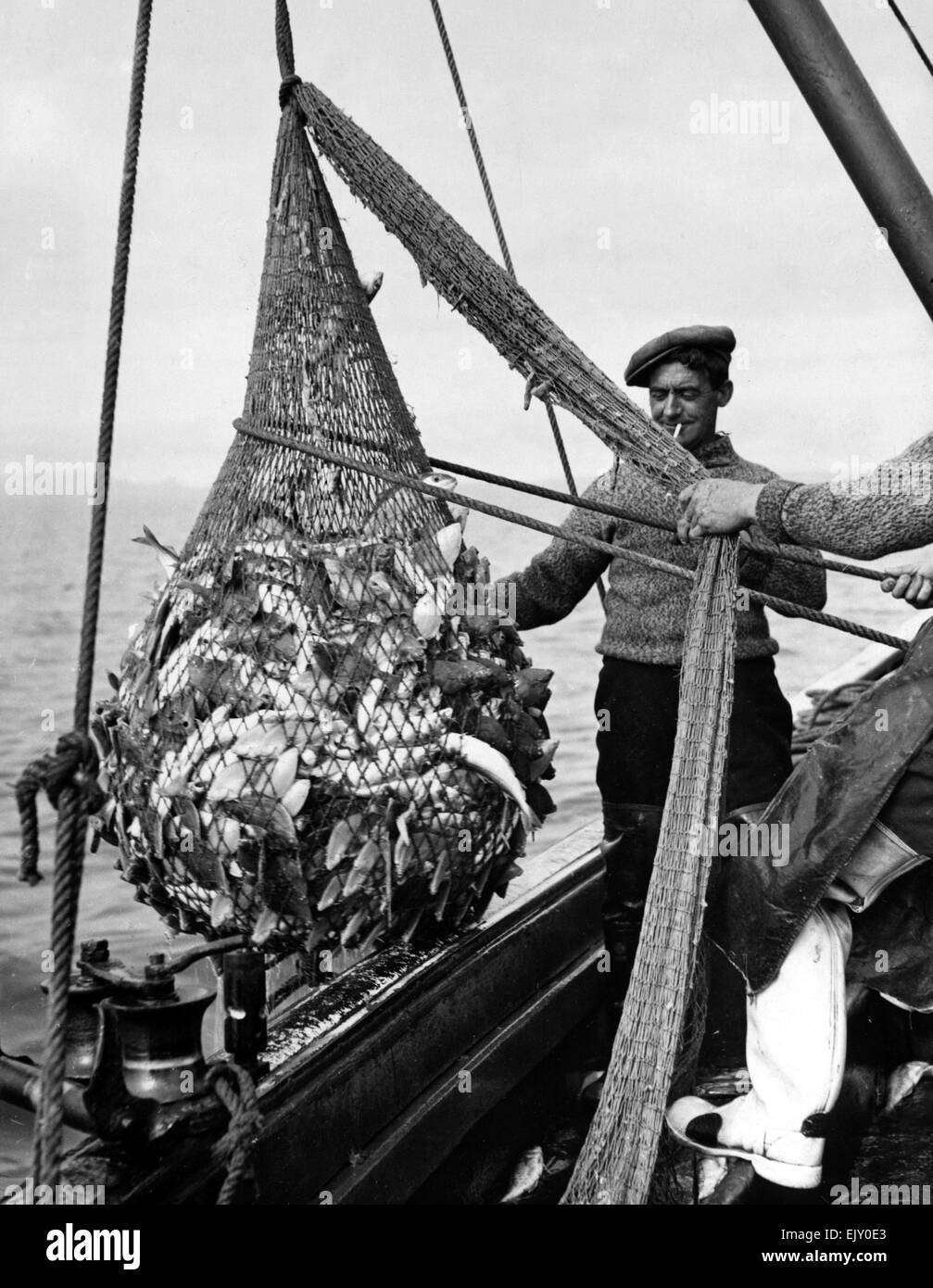 Un Lossiemouth pescatore con la sua cattura di pesce- Whitings, Codlings, nasello, suole di limone. Il 25 settembre 1937. Foto Stock